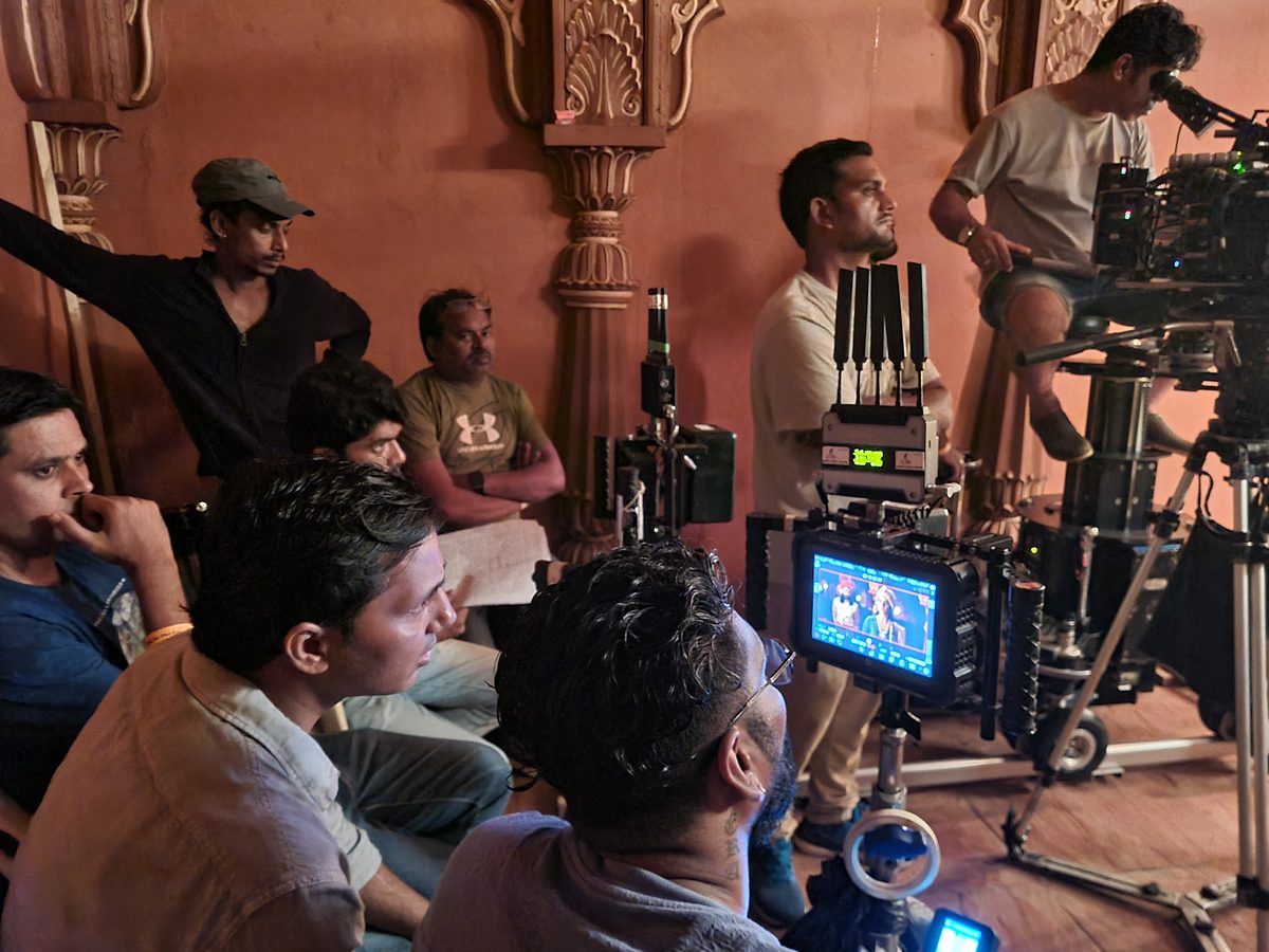 Nayki film crew watching a playback monitor on set